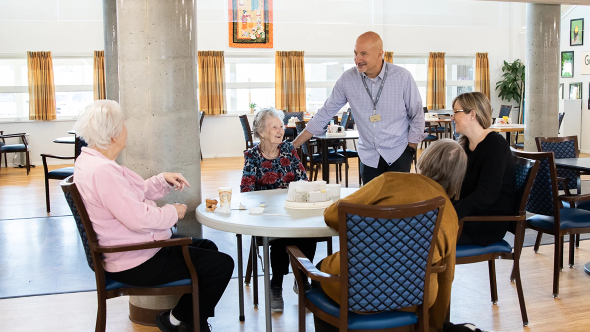 employee and residents laughing at a dinner table