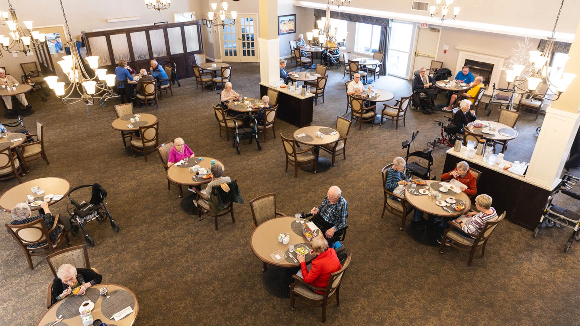 Seniors sitting in a dining hall enjoying food