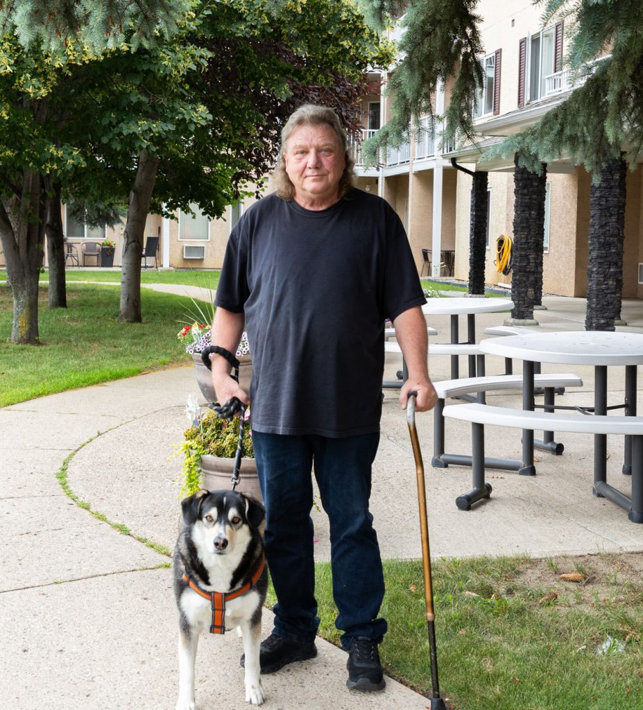 resident standing outside with dog